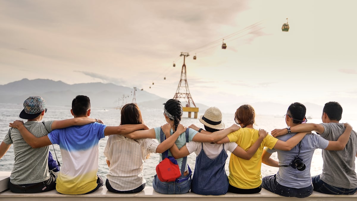 Friends sitting arm in arm at a viewpoint